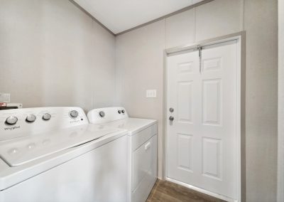Model laundry room with washer and dryer at Cedar Ridge Manufactured Homes in Wichita Kansas